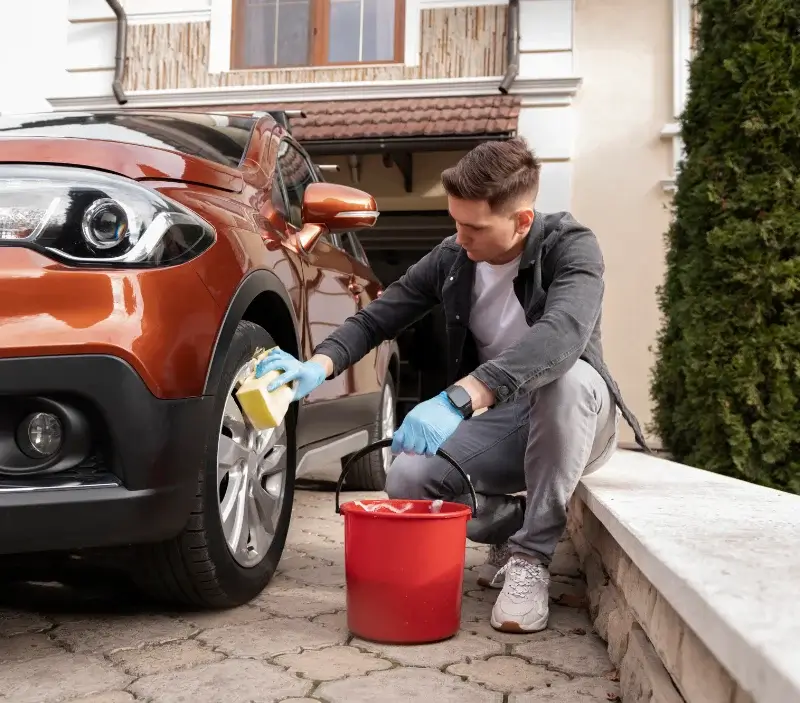 Lavage auto à domicile Castillon-la-Bataille : professionnel intervenant sur un véhicule